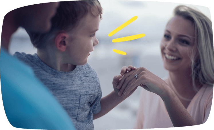 Mujer sonriendo mientras sostiene la mano de un niño pequeño